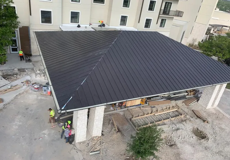 Metal roofing installation team working on a commercial building in Madison